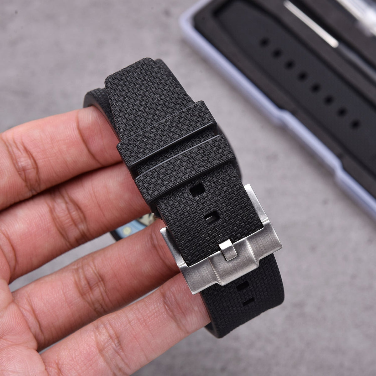 Rubber strap and case for AP x Swatch Black KronoKeeper – strap held in hand